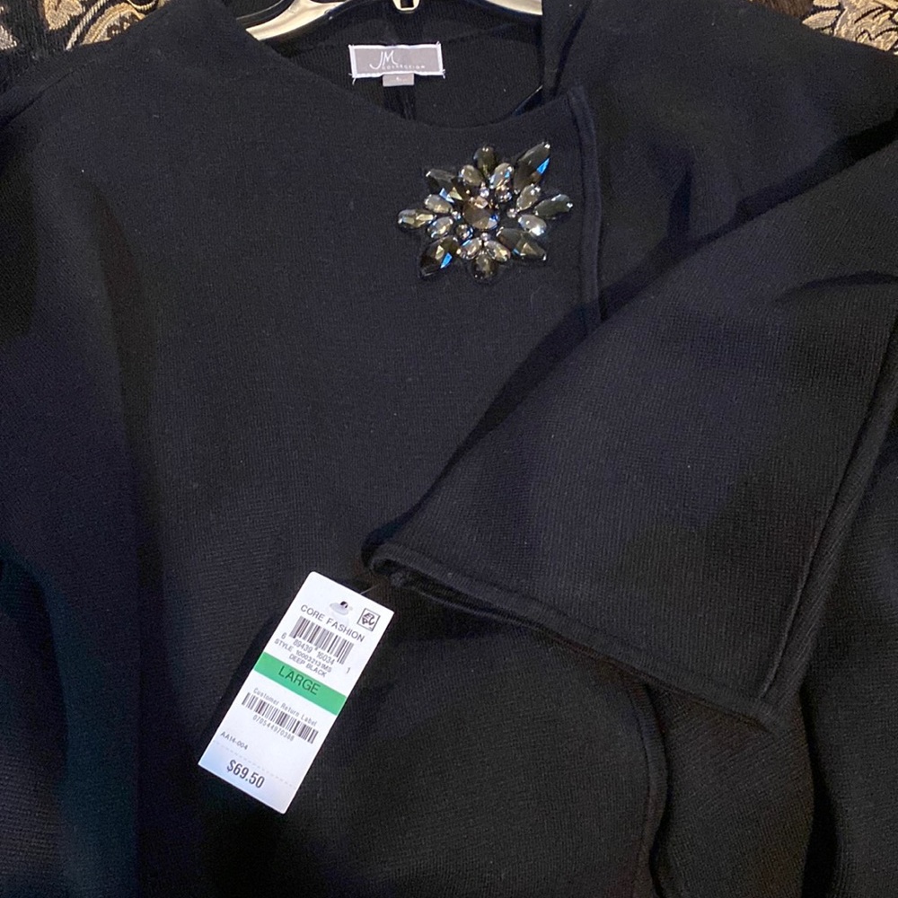 Stylist sweater w built-on broach. Beautifully designed. Black